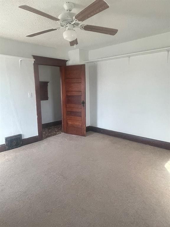 carpeted empty room with a textured ceiling and ceiling fan