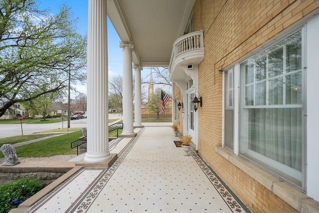 view of patio featuring a balcony and a porch