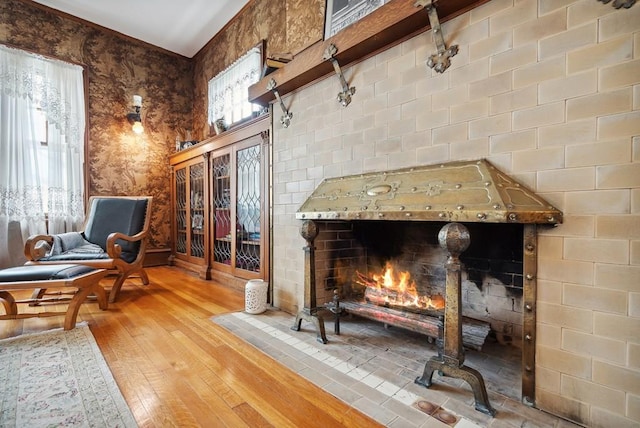 living area with plenty of natural light, a brick fireplace, and light wood-type flooring