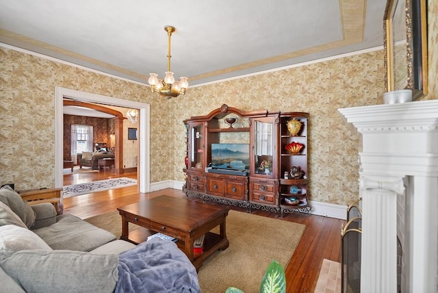 living room with crown molding, dark hardwood / wood-style floors, and a chandelier