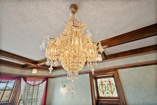 interior details with ornamental molding, coffered ceiling, beam ceiling, and a notable chandelier