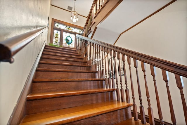 staircase featuring a notable chandelier and a high ceiling