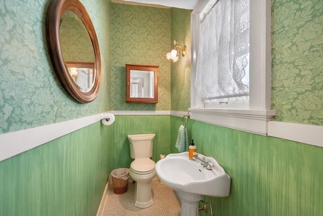 bathroom with toilet, tile patterned flooring, and sink