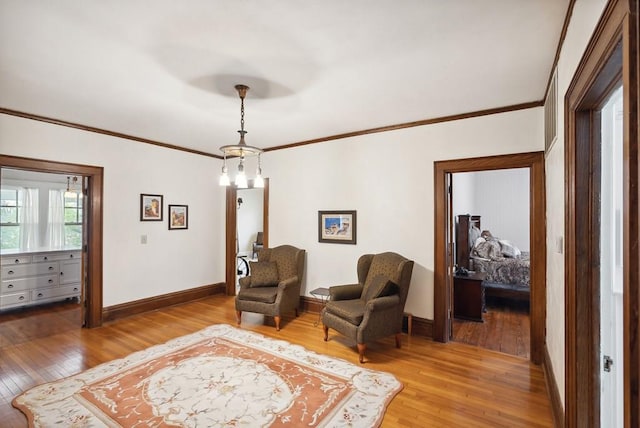 living area featuring hardwood / wood-style flooring and ornamental molding