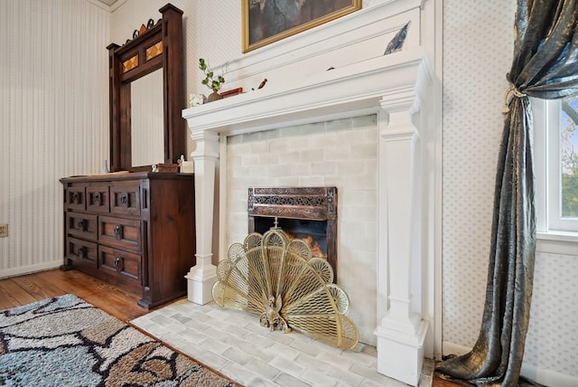 interior space with hardwood / wood-style flooring, a fireplace, and ornate columns