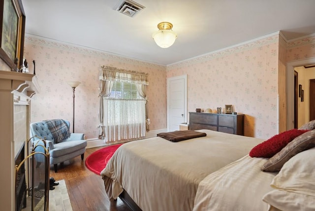 bedroom with hardwood / wood-style floors and ornamental molding