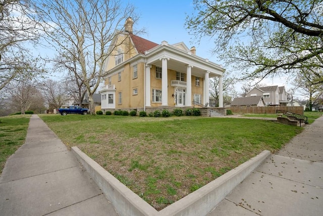 neoclassical home with a porch and a front lawn