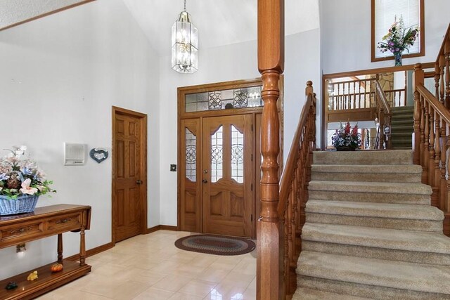 entrance foyer featuring a chandelier, light tile patterned floors, and a high ceiling