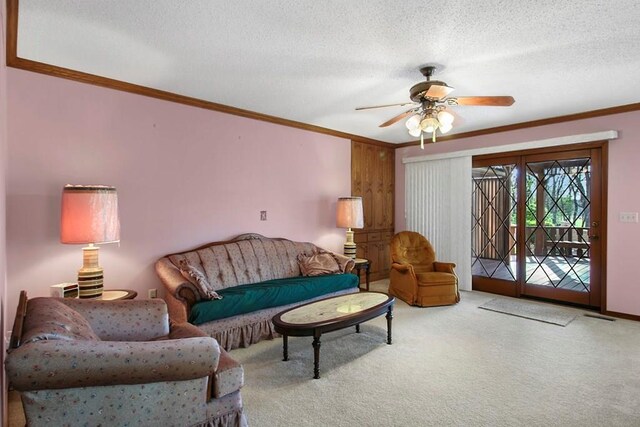 carpeted living room with ornamental molding, a textured ceiling, and ceiling fan