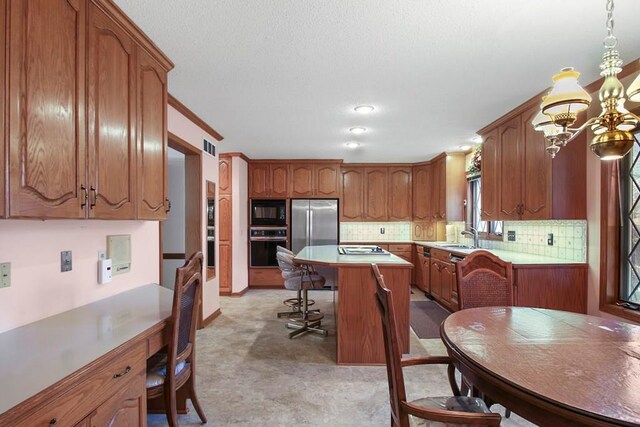 kitchen featuring a center island, stainless steel appliances, sink, and tasteful backsplash