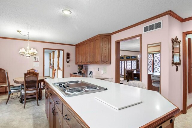 kitchen featuring a textured ceiling, stainless steel stovetop, an inviting chandelier, and decorative light fixtures