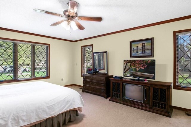 bedroom featuring ornamental molding, light colored carpet, and ceiling fan