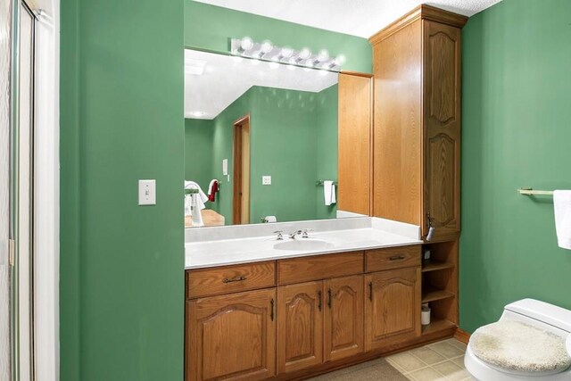 bathroom with tile patterned flooring, toilet, and vanity