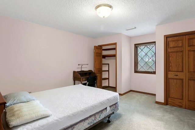 carpeted bedroom with a textured ceiling