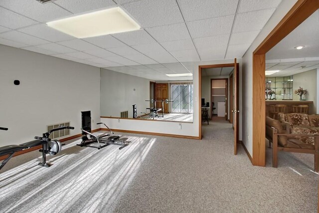 exercise area featuring a paneled ceiling and carpet floors