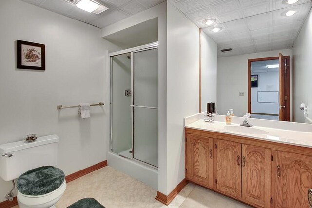 bathroom featuring a shower with door, vanity, and toilet