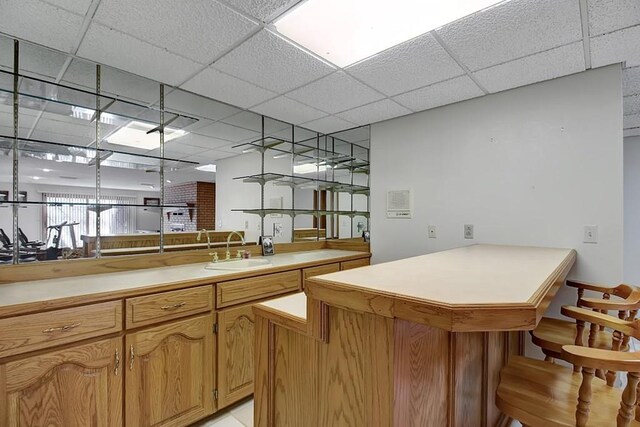 bar with sink and a drop ceiling