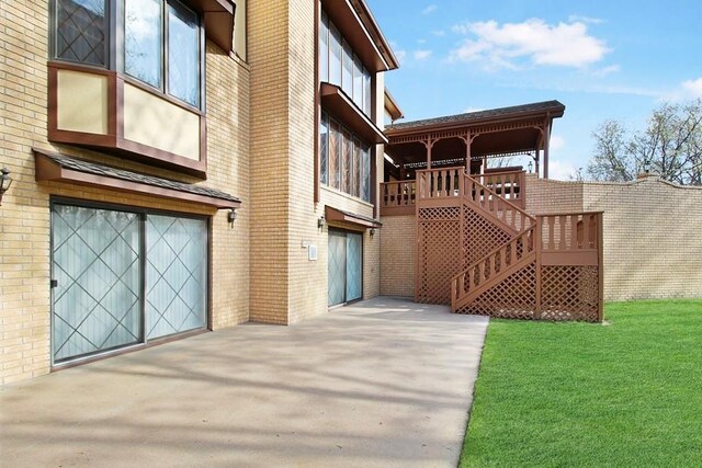 exterior space featuring a garage, a lawn, and a deck