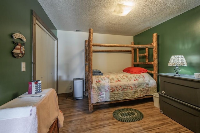 bedroom featuring a closet, a textured ceiling, and hardwood / wood-style flooring