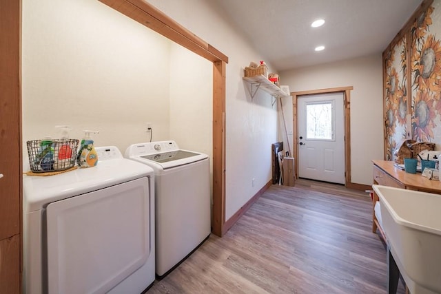 clothes washing area featuring light hardwood / wood-style flooring and independent washer and dryer