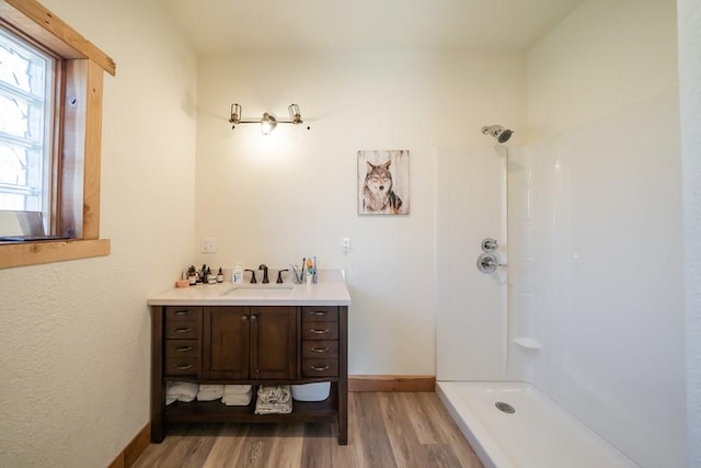 bathroom with a shower, vanity, and wood-type flooring