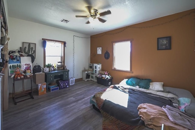 bedroom with dark hardwood / wood-style flooring and ceiling fan