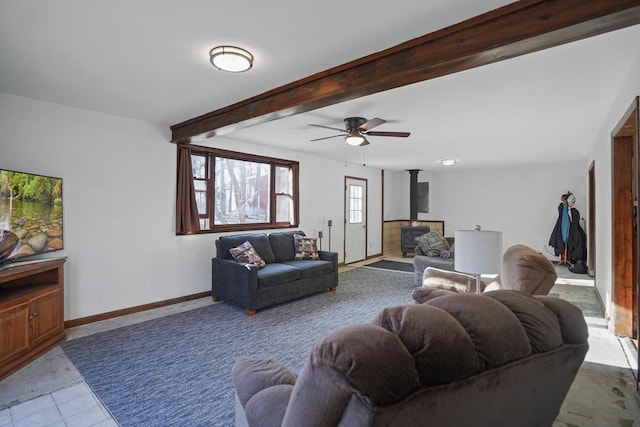 living room with beam ceiling, a wood stove, and ceiling fan