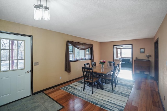 dining area featuring dark wood-type flooring and a textured ceiling