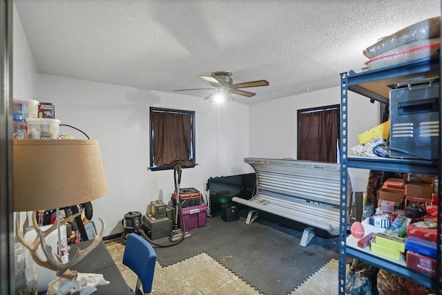 misc room with ceiling fan and a textured ceiling