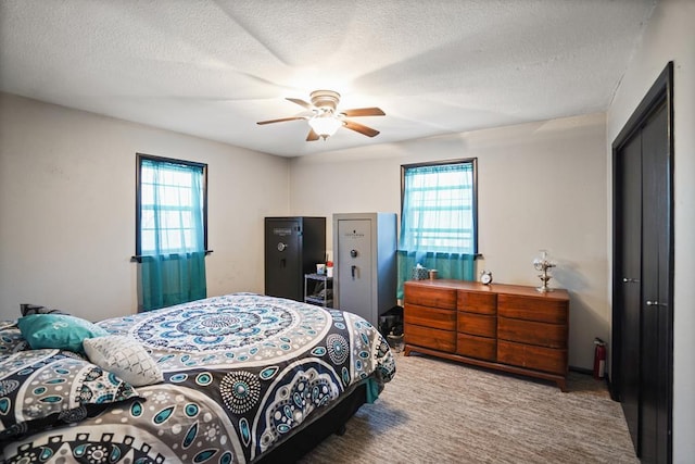 bedroom featuring multiple windows, a textured ceiling, a closet, and ceiling fan