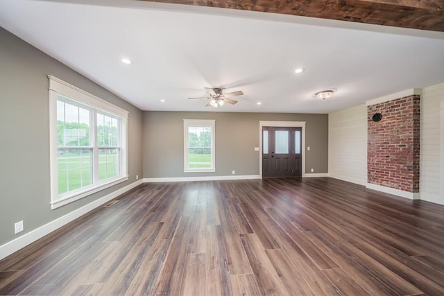 unfurnished living room with brick wall, ceiling fan, and dark hardwood / wood-style floors