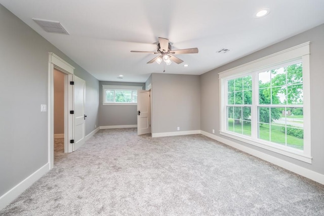 carpeted spare room featuring ceiling fan