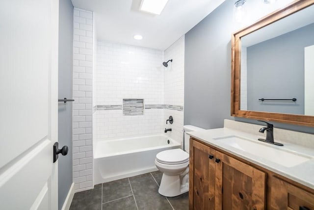 full bathroom featuring tile patterned flooring, toilet, tiled shower / bath combo, and vanity