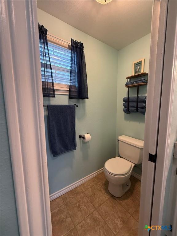 68 Silkstocking St, Port Lavaca, TX 77979 - bathroom with toilet, baseboards, and tile patterned floors