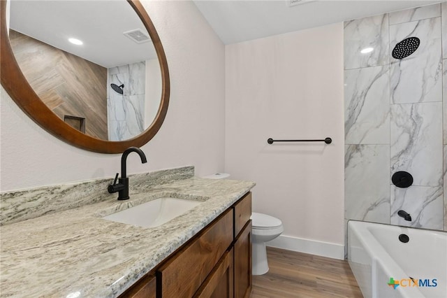 bathroom with visible vents, vanity, wood finished floors, toilet, and baseboards