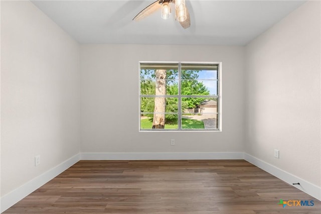 spare room with baseboards, a ceiling fan, and wood finished floors