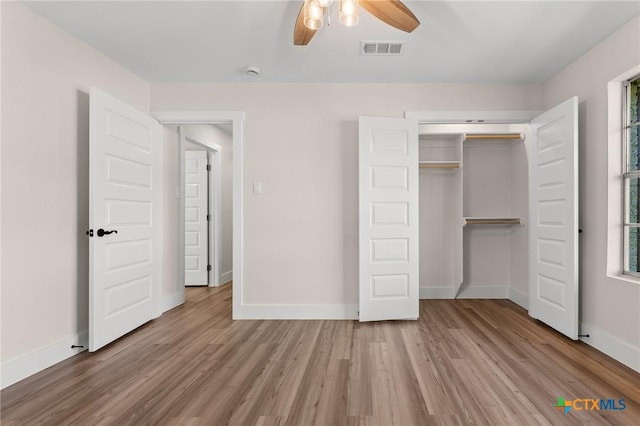 unfurnished bedroom featuring visible vents, baseboards, ceiling fan, and wood finished floors