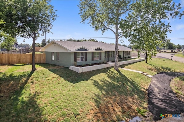 ranch-style house with a front lawn and fence