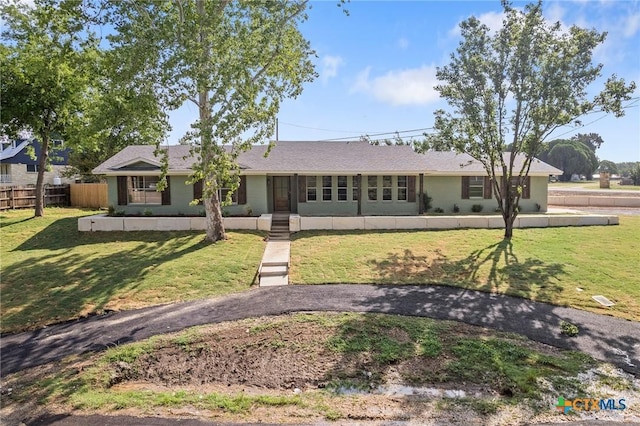 ranch-style house featuring fence and a front yard
