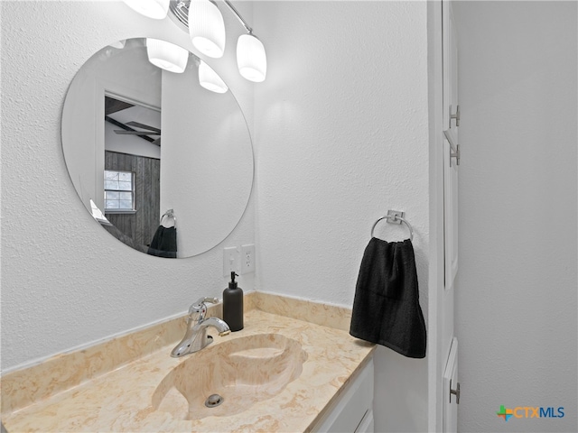 bathroom featuring a textured wall and vanity