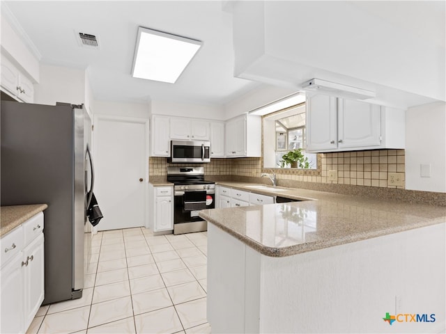 kitchen with visible vents, backsplash, appliances with stainless steel finishes, a sink, and a peninsula