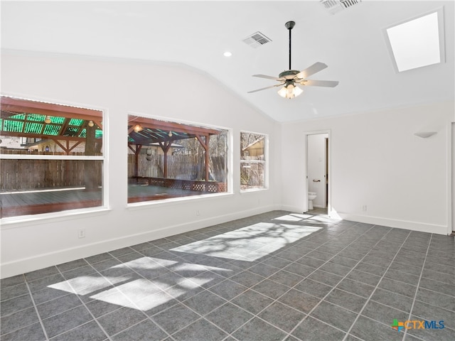 empty room featuring lofted ceiling, a ceiling fan, visible vents, and baseboards