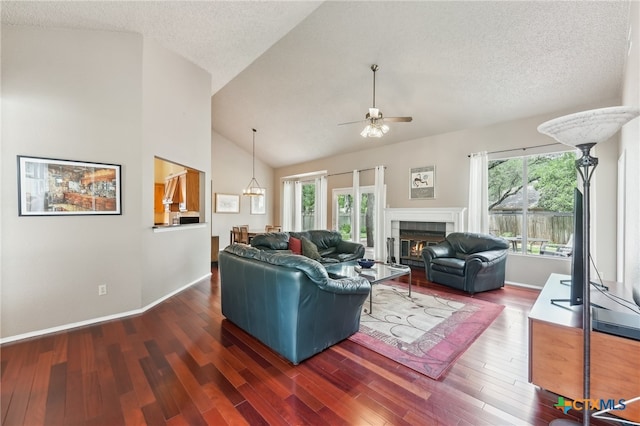8302 Dove Valley Cv, Austin, TX 78729 - living room featuring a ceiling fan, a tile fireplace, wood finished floors, high vaulted ceiling, and a textured ceiling