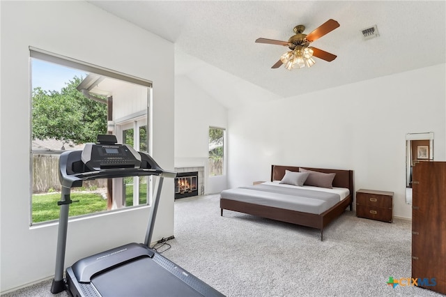 8302 Dove Valley Cv, Austin, TX 78729 - carpeted bedroom with vaulted ceiling, a tiled fireplace, and a ceiling fan