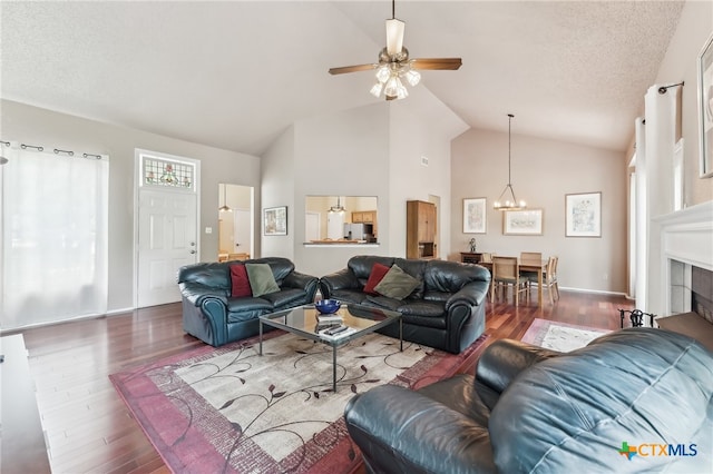 8302 Dove Valley Cv, Austin, TX 78729 - living room featuring vaulted ceiling, a chandelier, wood finished floors, a ceiling fan, and a fireplace