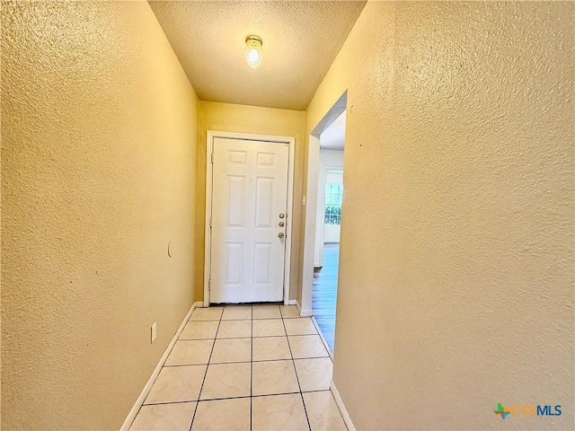 3807 Sunflower Dr, Killeen, TX 76542 - doorway featuring a textured wall, light tile patterned floors, and a textured ceiling