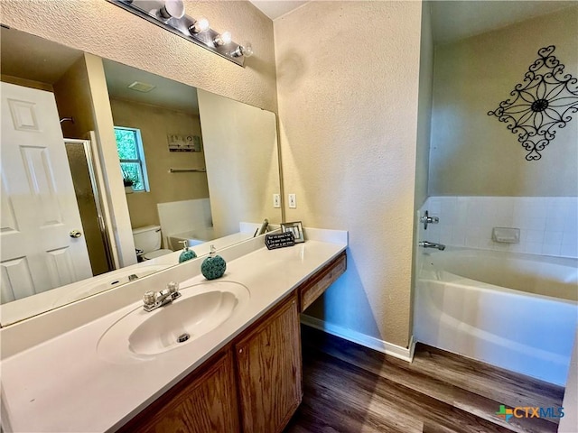 3807 Sunflower Dr, Killeen, TX 76542 - full bath featuring wood finished floors, a garden tub, a textured wall, vanity, and a stall shower