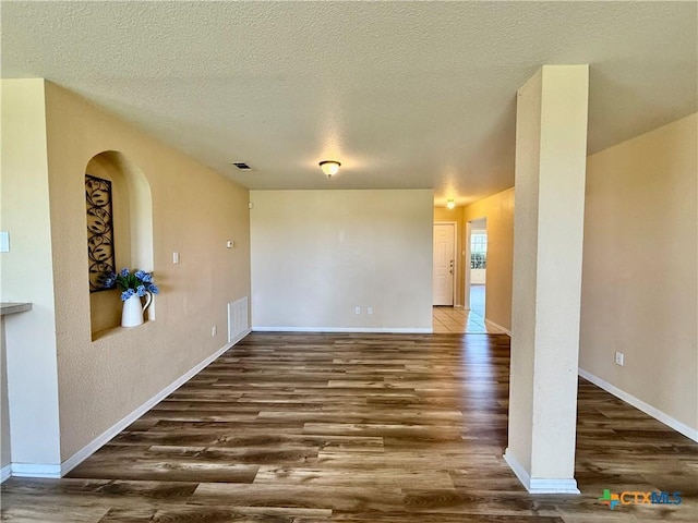 3807 Sunflower Dr, Killeen, TX 76542 - unfurnished room featuring wood finished floors, a textured ceiling, and arched walkways