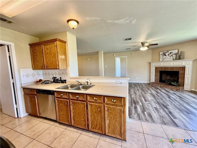 3807 Sunflower Dr, Killeen, TX 76542 - kitchen featuring dishwasher, a peninsula, brown cabinetry, a ceiling fan, and light countertops
