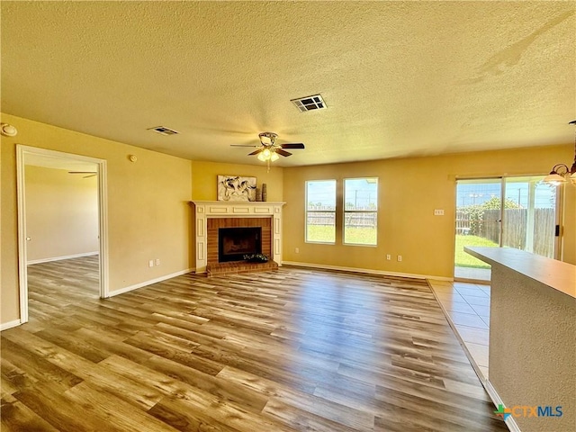 3807 Sunflower Dr, Killeen, TX 76542 - unfurnished living room with a textured ceiling, wood finished floors, a ceiling fan, and plenty of natural light
